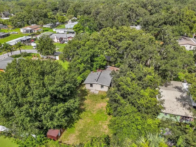 an aerial view of residential houses with outdoor space and trees