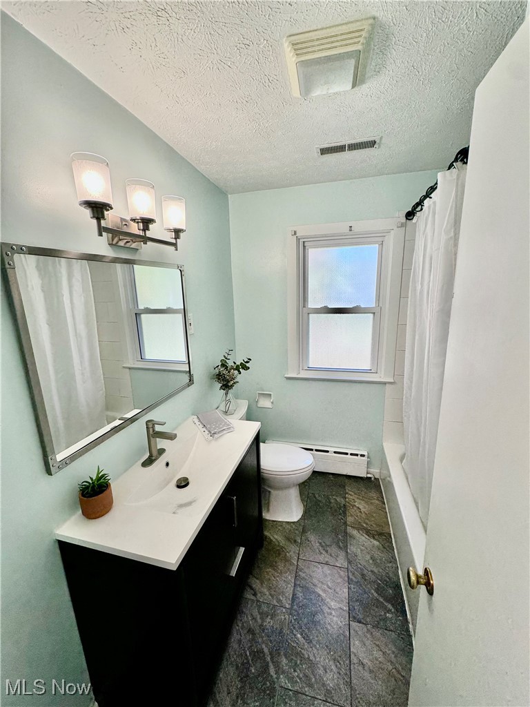 1729 East Pleasant Valley Road Independence, OH 44131 - Photo 25 of 41 Full bathroom with toilet, a textured ceiling, baseboard heating, and vanity