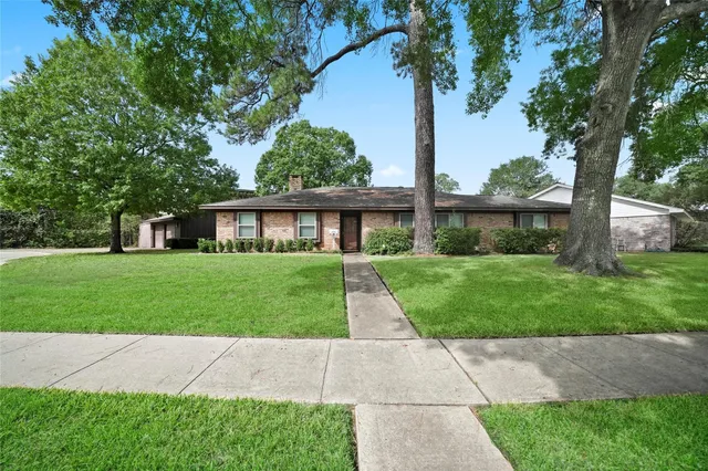 front view of a house and a yard and trees