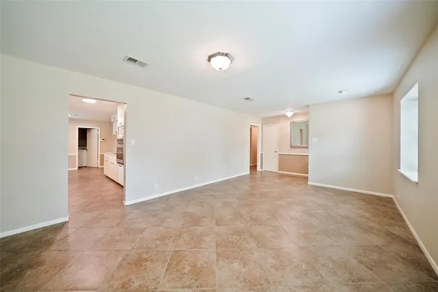 an empty room with kitchen and fireplace