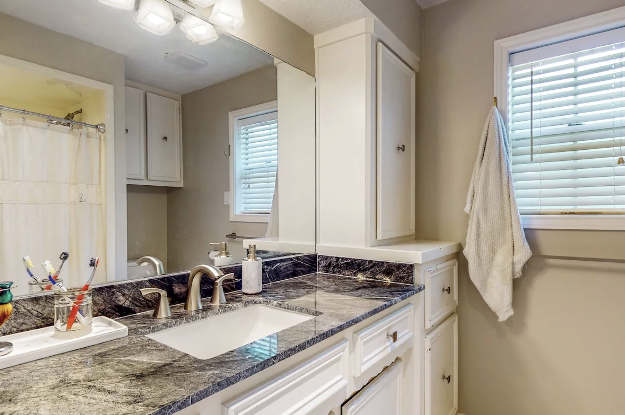 30819 Quinn Road Tomball, TX 77375 - Photo 13 of 30 a bathroom with a granite countertop sink and a mirror
