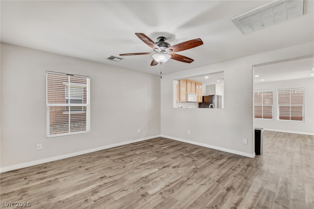 11159 Ranch Valley Street Las Vegas, NV 89179 - Photo 5 of 27 A spacious living area with durable wood-look flooring flows into an adjacent kitchen, ready for everyday living.
