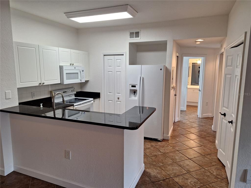 5140 Northridge Road, Unit 102 Sarasota, FL 34238 - Photo 3 of 32 a kitchen with stainless steel appliances granite countertop a sink and a refrigerator