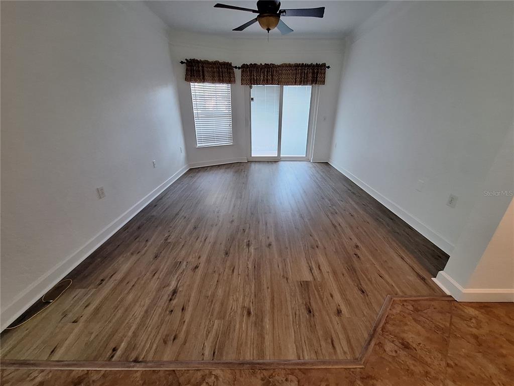 5140 Northridge Road, Unit 102 Sarasota, FL 34238 - Photo 8 of 32 a view of an empty room with a window and wooden floor