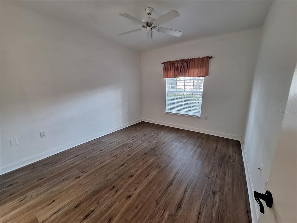 5140 Northridge Road, Unit 102 Sarasota, FL 34238 - Photo 9 of 32 wooden floor in an empty room with a window