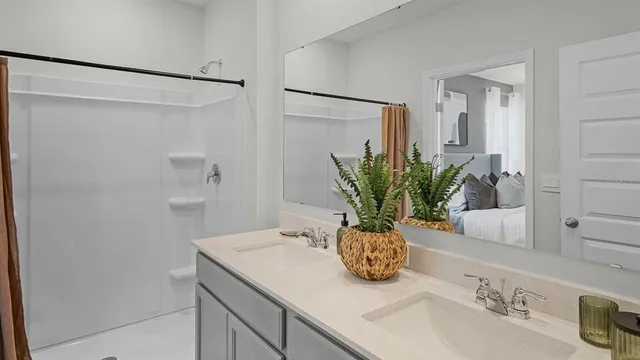 a bathroom with a granite countertop sink a mirror and a shower