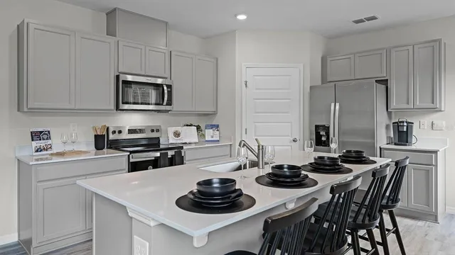 a kitchen with stainless steel appliances a stove a sink and a refrigerator