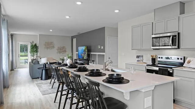 a kitchen with sink stove microwave and dining table