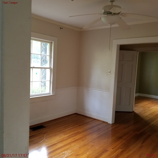 705 Charlse Drive Perry, GA 31069 - Photo 12 of 20 an empty room with wooden floor cabinet and windows