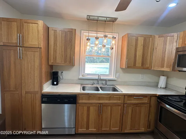 a kitchen with stainless steel appliances a kitchen island hardwood floor sink stove dining table and chairs