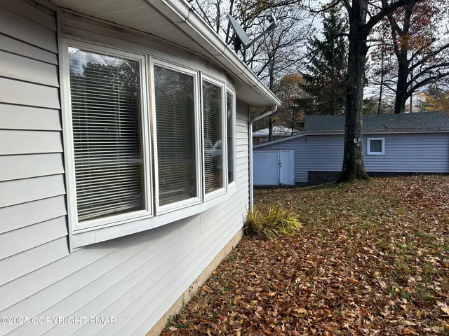 a view of a house with a large window and wooden fence
