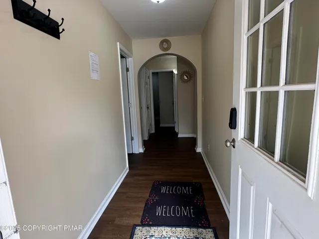 a view of a hallway with wooden floor and staircase