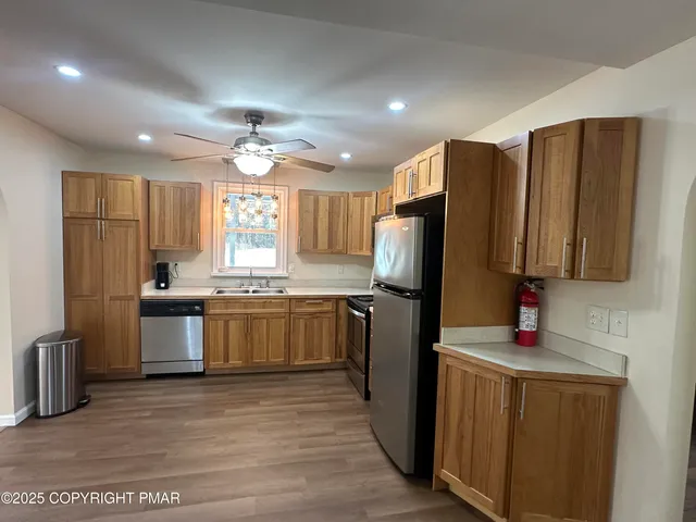 a kitchen with stainless steel appliances granite countertop a refrigerator stove and sink