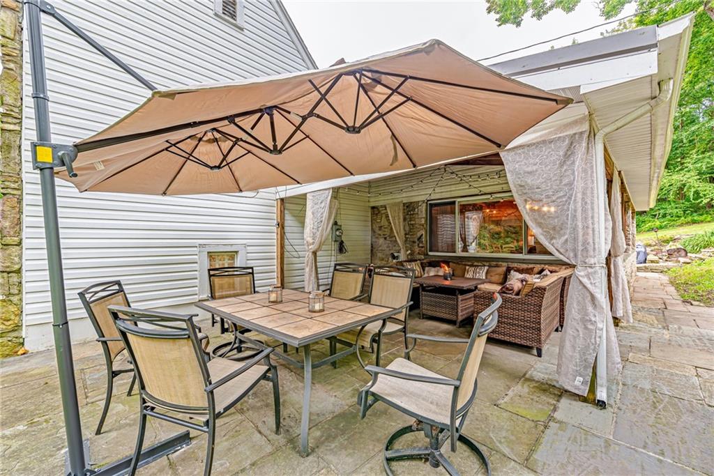 1100 State Rt 30 Laughlintown, PA 15655 - Photo 42 of 50 a view of a patio with table and chairs under an umbrella