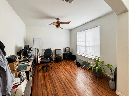 a living room with furniture floor to ceiling window and wooden floor