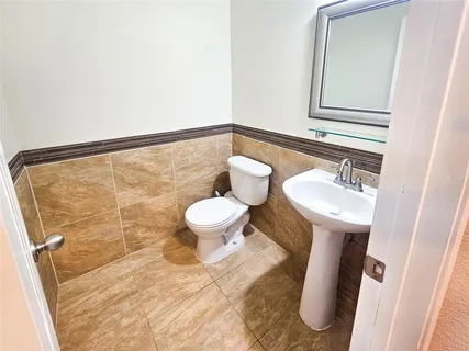 a bathroom with a toilet sink and mirror