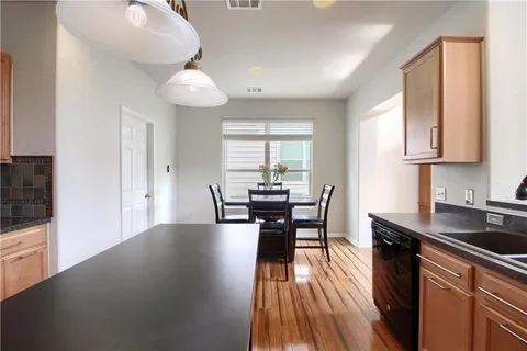 a kitchen with stainless steel appliances granite countertop a stove top oven a sink with dining table and chairs