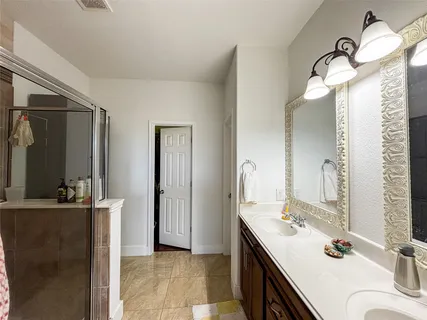 a bathroom with a double vanity sink mirror and shower