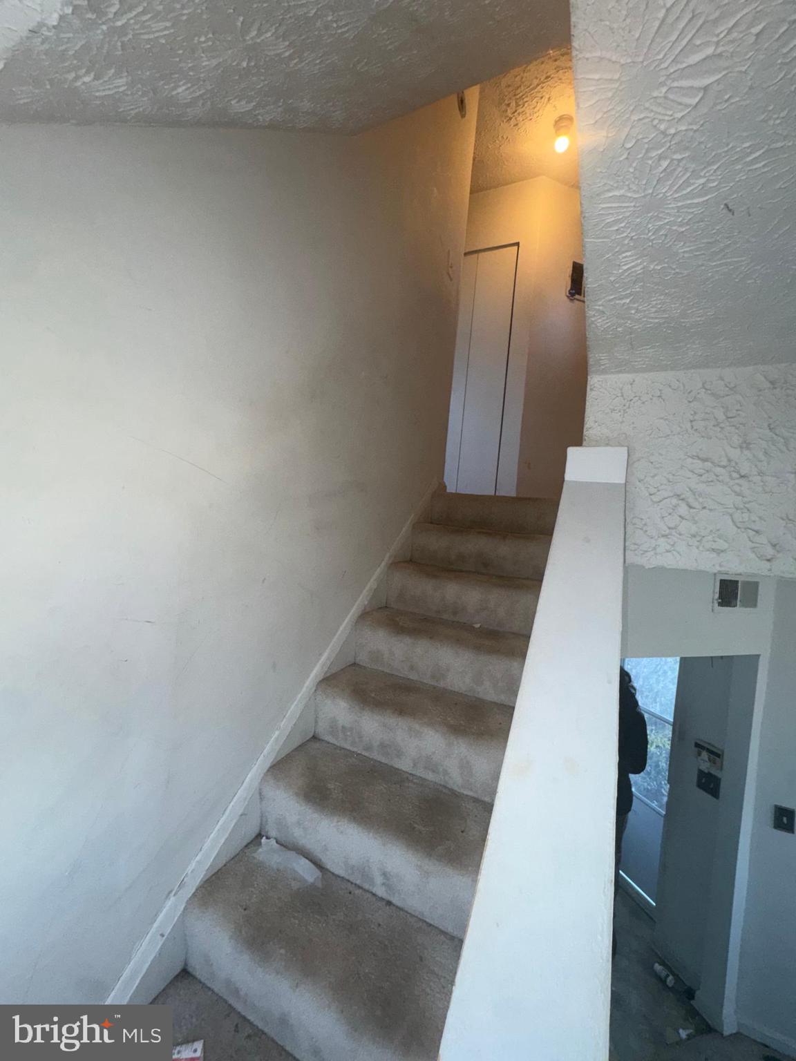 515 Cherry Hill Road Baltimore, MD 21225 - Photo 35 of 62 a view of staircase with white walls and door