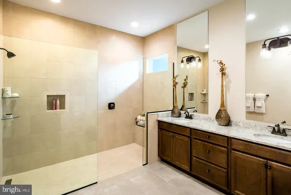 a spacious bathroom with a granite countertop sink mirror and shower
