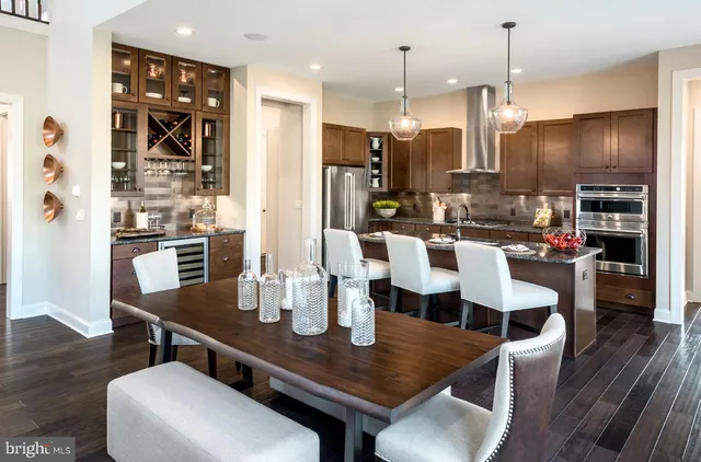 a dining room with stainless steel appliances kitchen island granite countertop a dining table chairs and view living room
