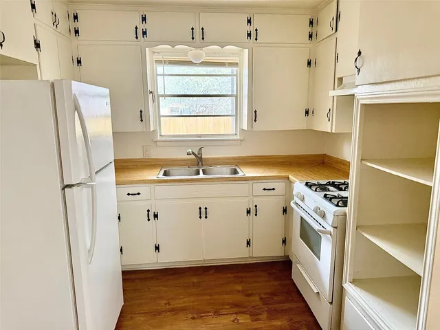 a kitchen with white cabinets and white appliances