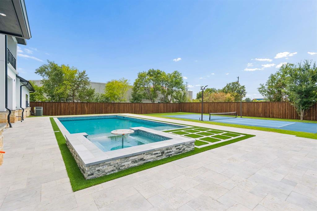 6606 Curtis Road Colleyville, TX 76034 - Photo 37 of 39 Expansive backyard featuring a rectangular swimming pool, integrated spa, blue hard-surface court, and a wood privacy fence