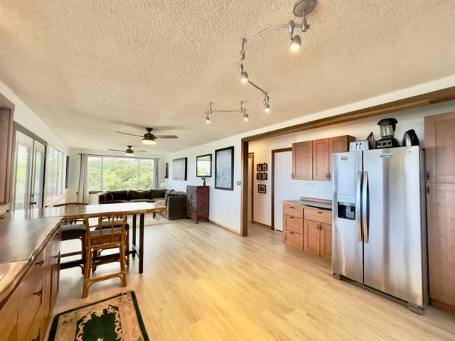 81-1010 St John's Road Kealakekua, HI 96750 - Photo 9 of 30 a open kitchen with stainless steel appliances granite countertop a refrigerator dining table and chairs