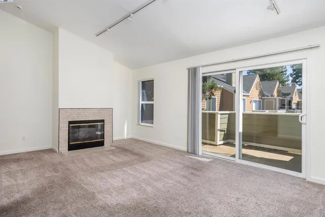 an empty room with floor to ceiling window and fireplace