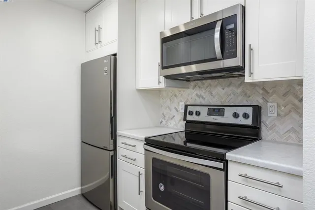 a kitchen with stainless steel appliances a stove microwave and refrigerator