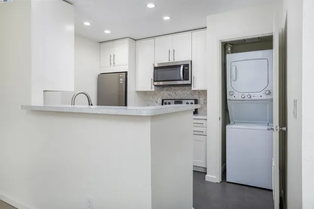 a kitchen with a refrigerator a microwave a sink and cabinets