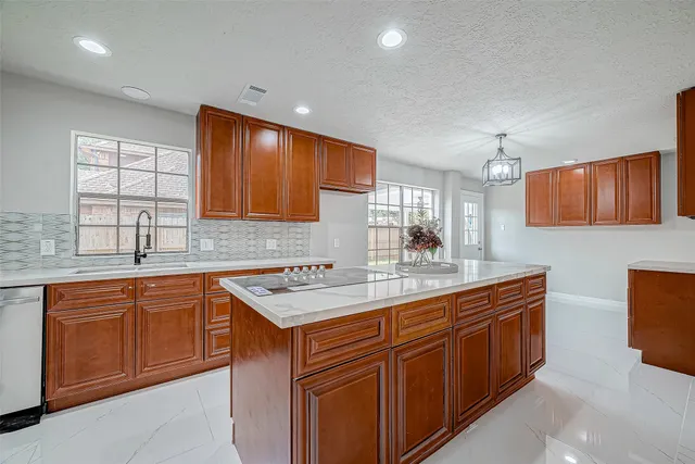 a kitchen with stainless steel appliances granite countertop a sink stove and cabinets