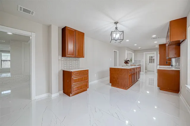 a living room with couches and kitchen view with wooden floor