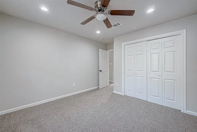 an empty room with chandelier fan