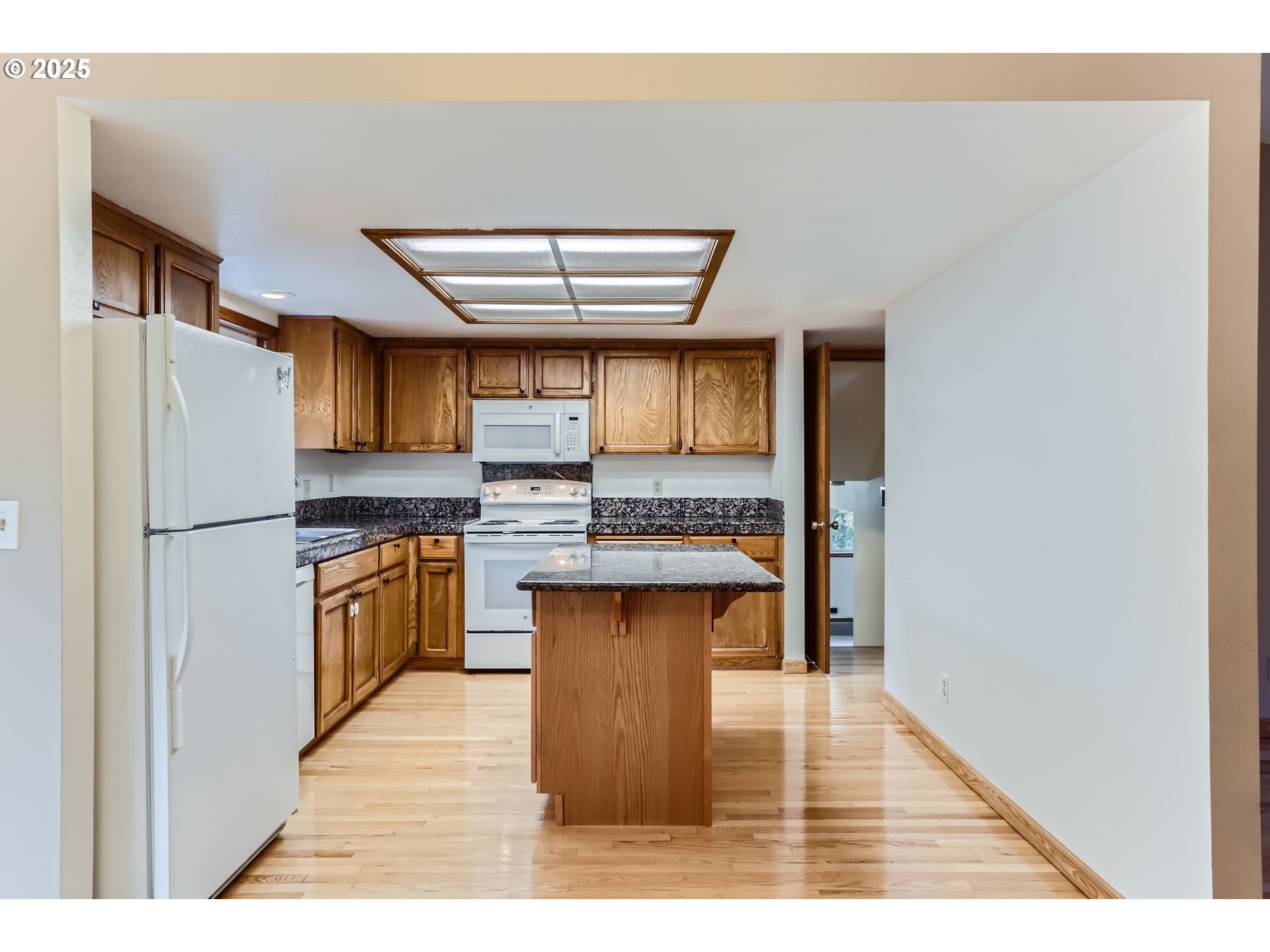 6518 Southwest 35th Avenue Portland, OR 97221 - Photo 11 of 36 a kitchen with stainless steel appliances granite countertop a refrigerator a sink dishwasher and a stove with wooden floor