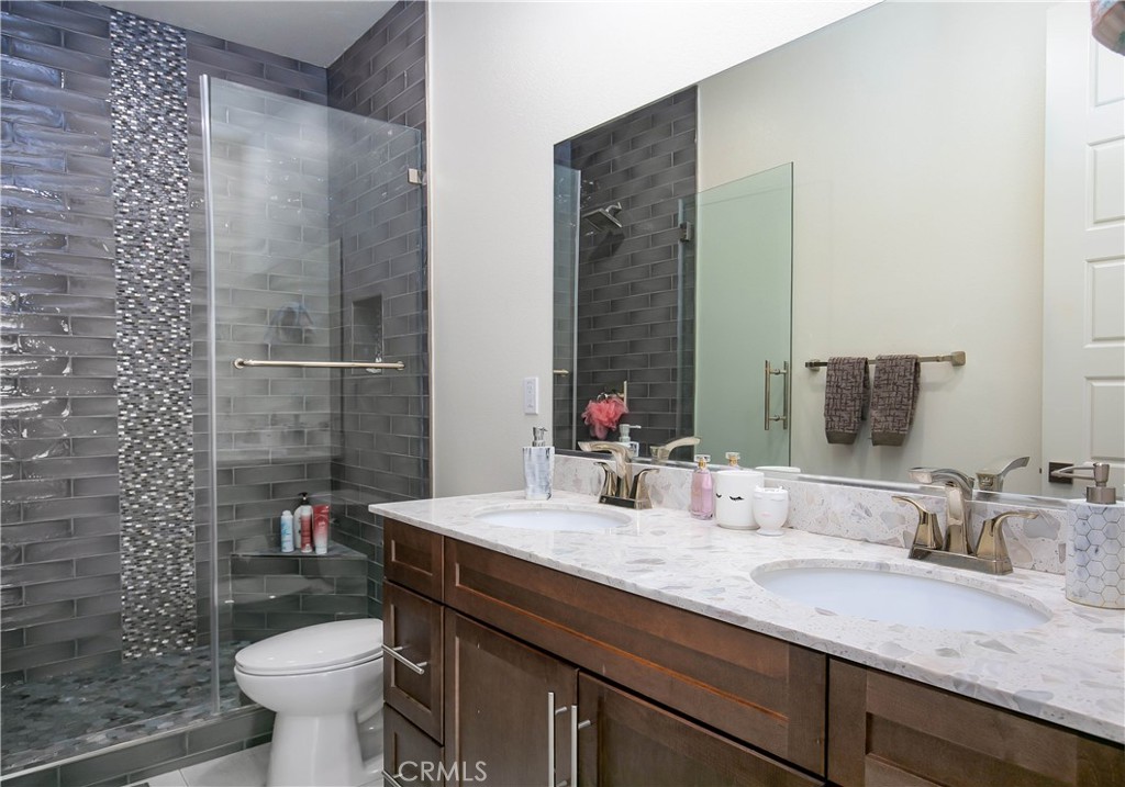 19680 Griffith Drive Saugus, CA 91350 - Photo 34 of 49 a bathroom with a granite countertop sink a toilet a mirror and shower