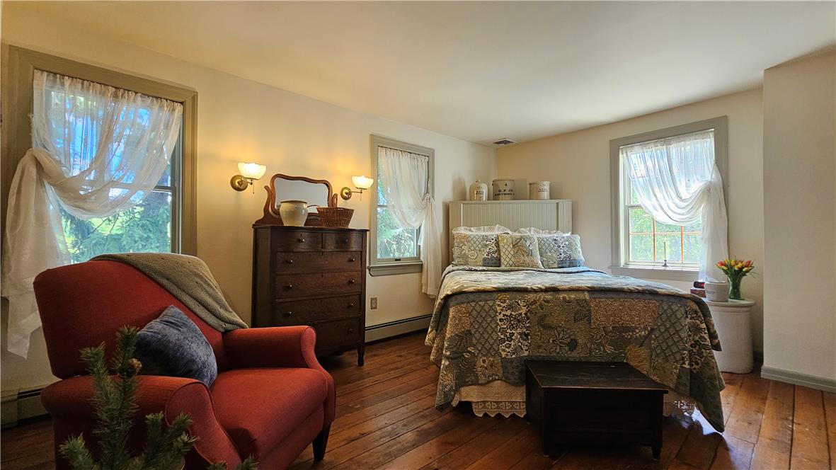 585 Buttermilk Road Hellertown, PA 18055 - Photo 32 of 82 Warm wood flooring extends throughout this well-lit bedroom, offering cozy comfort.