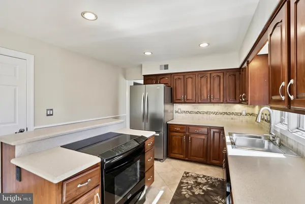 a kitchen with stainless steel appliances granite countertop a stove a sink and a refrigerator