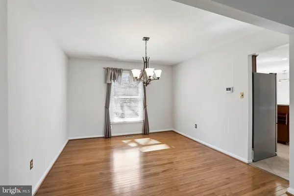 a view of a room with wooden floor chandelier and a window