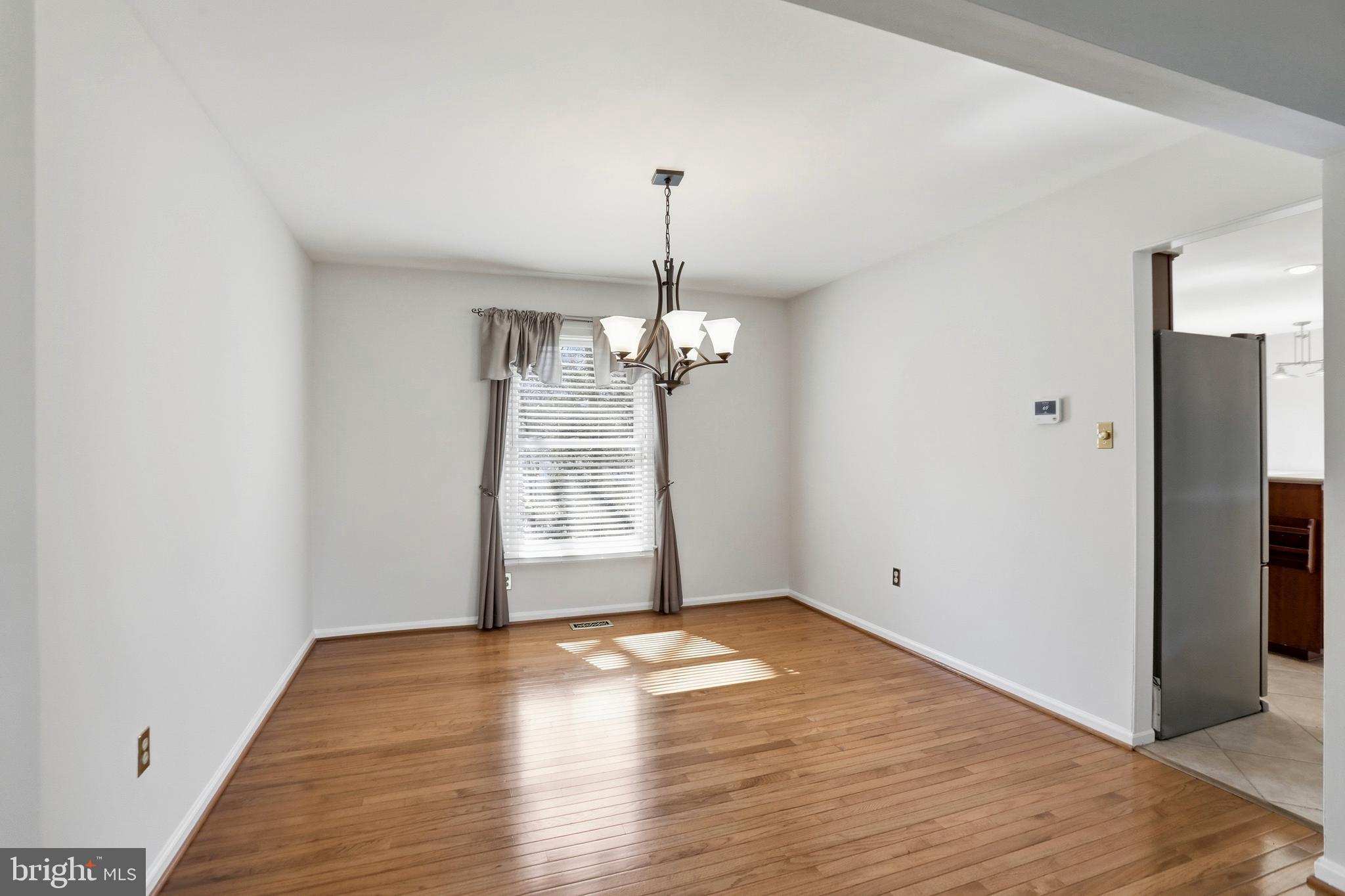 9202 Rockefeller Lane Springfield, VA 22153 - Photo 26 of 38 a view of a room with wooden floor chandelier and a window