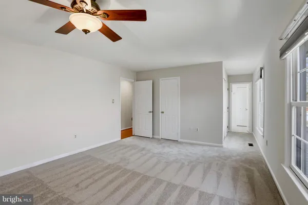 a view of a room with a ceiling fan and window
