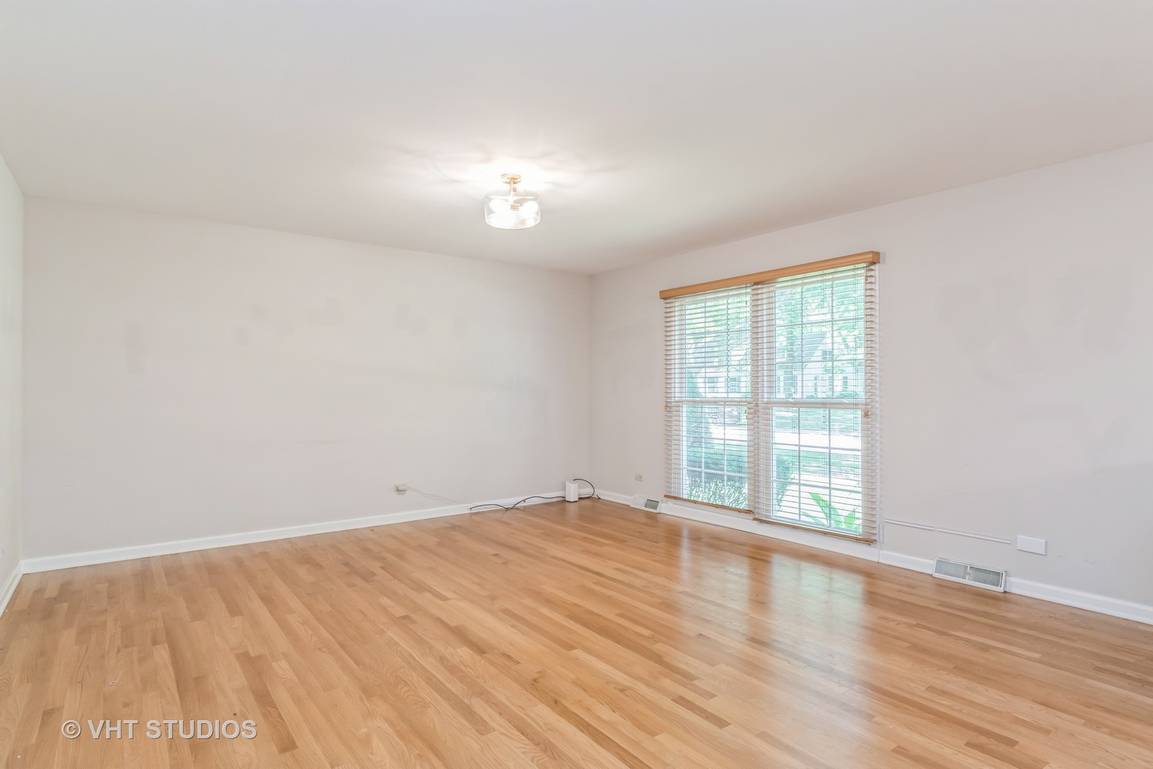 76 West Bailey Road Naperville, IL 60565 - Photo 2 of 20 an empty room with wooden floor and windows