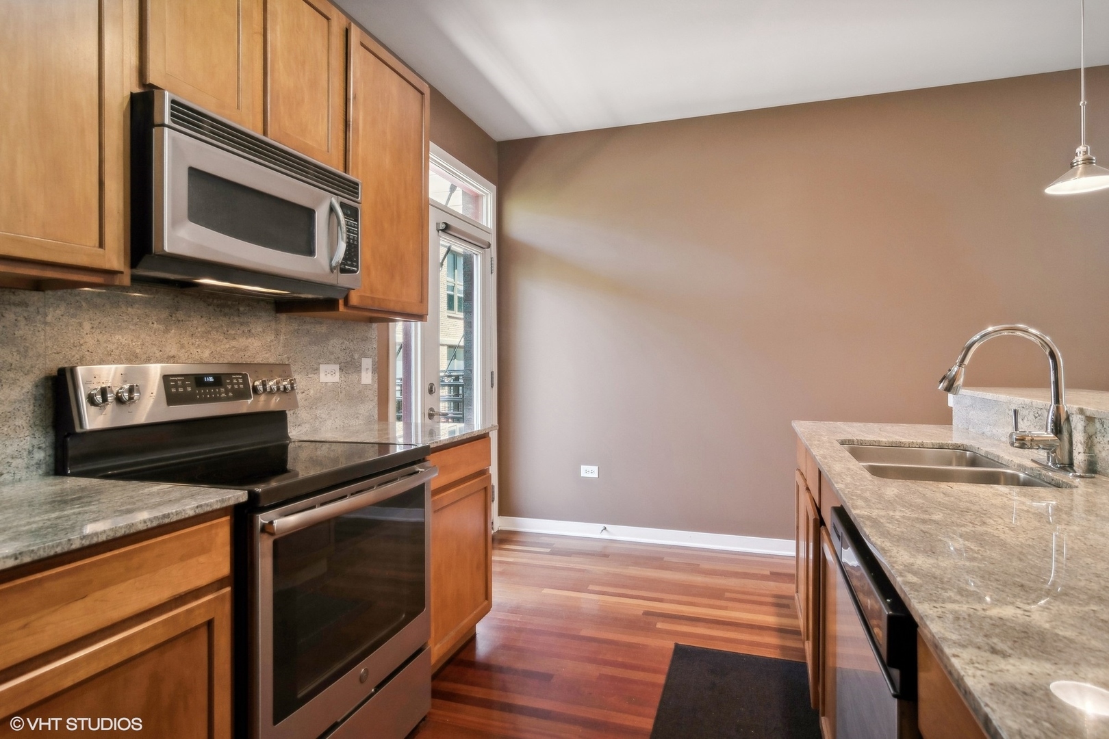 1244 West Monroe Street, Unit 7 Chicago, IL 60607 - Photo 9 of 18 a kitchen with stainless steel appliances granite countertop a stove microwave and sink