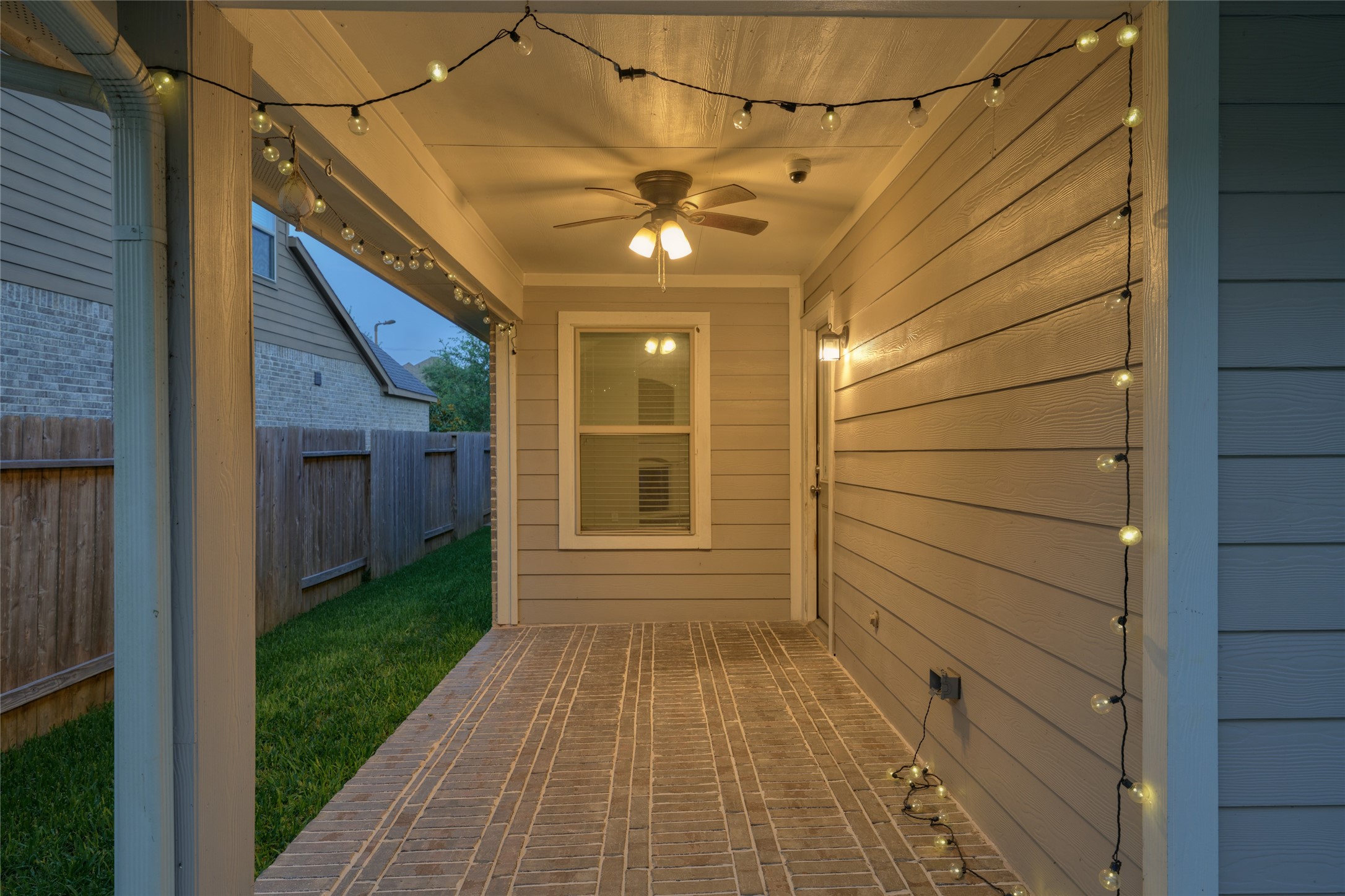 116 Fox Trail Road Montgomery, TX 77316 - Photo 38 of 50 The covered patio features stylish string lighting, a ceiling fan, and durable brick flooring, perfect for relaxing evenings.