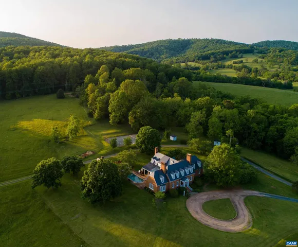 an aerial view of a house with garden space and lake view