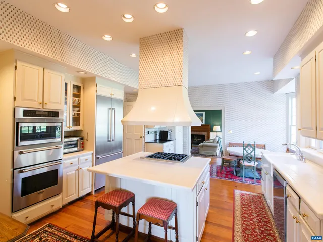 a kitchen with stainless steel appliances granite countertop a stove refrigerator and a view of living room
