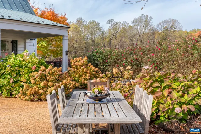 a view of a house with a big yard and large tree