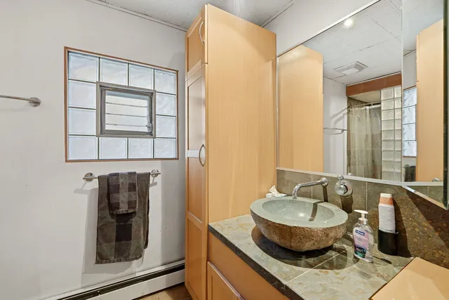 a bathroom with a granite countertop sink and a mirror