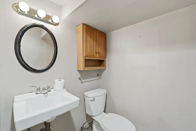 a bathroom with a toilet a sink and a mirror