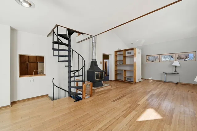 a view of a livingroom with wooden floor and stairs